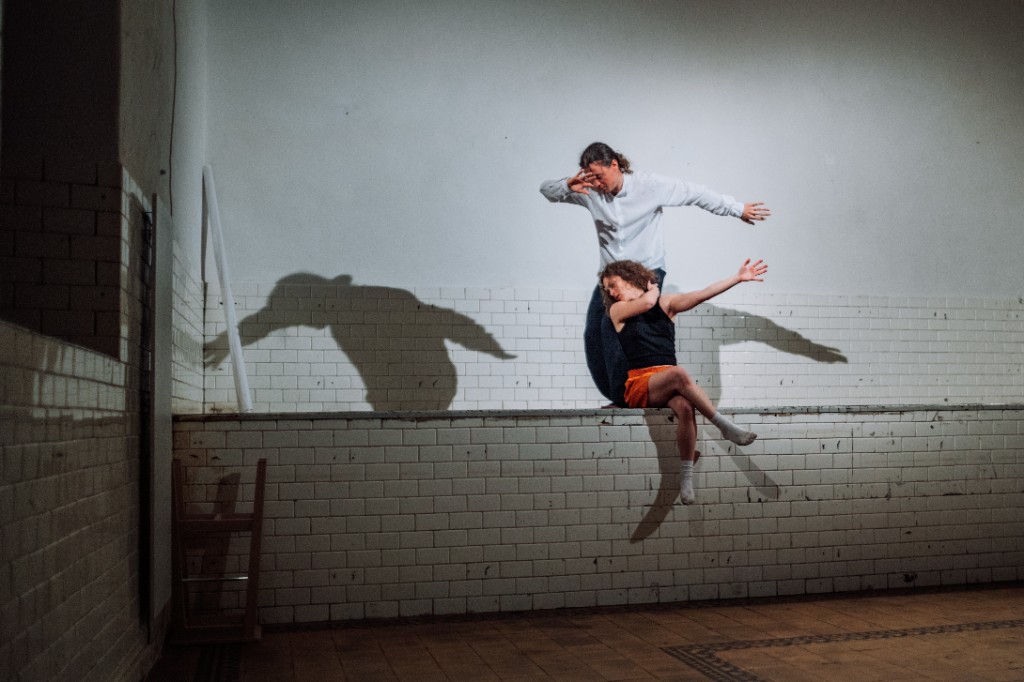 Dva tanečníci v prostoru, stíny na bílé zdi — IMMEDIATUS BIENNALE. Foto Marek Jančuch, září 2024.